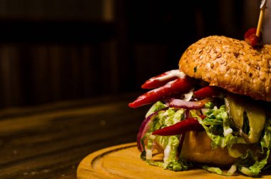 Pastırmalı hamburger ve ahşap masa.