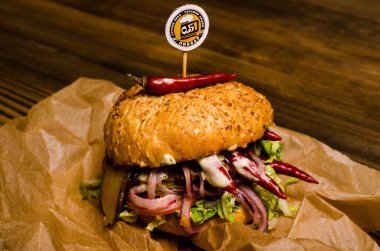 Pastırmalı hamburger ve ahşap masa.