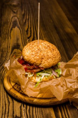 Pastırmalı hamburger ve ahşap masa.