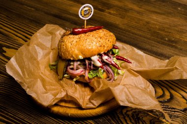 Pastırmalı hamburger ve ahşap masa.