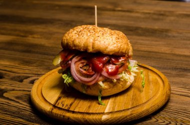 Pastırmalı hamburger ve ahşap masa.