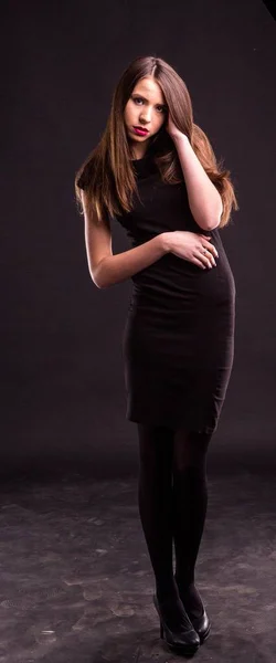 Портрет красивой молодой женщины в черном платье с прохладным макияжем и хорошей кожей. Студия, черный фон . — стоковое фото