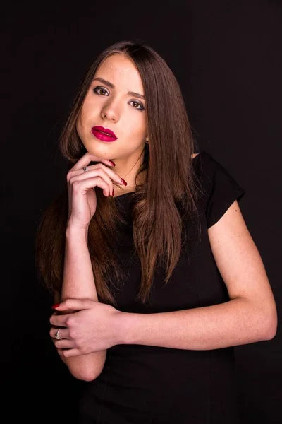 Porträt einer schönen jungen Frau in einem schwarzen Kleid mit coolem Make-up und guter Haut. Studio, schwarzer Hintergrund. — Stockfoto