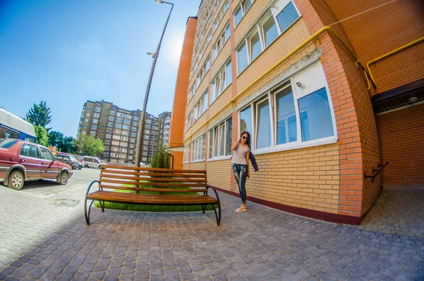 Felice ragazza elegante in abito alla moda con borsa a tracolla, passeggiando per la City Street e mostrando sorriso dentato alla fotocamera . — Foto Stock