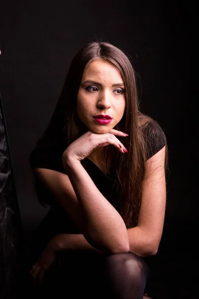 Портрет красивой молодой женщины в черном платье с прохладным макияжем и хорошей кожей. Студия, черный фон . — стоковое фото