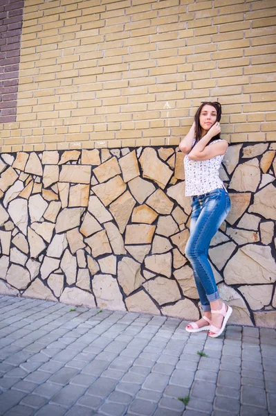 Menina elegante feliz na roupa da moda com bolsa de ombro, andando na rua da cidade e mostrando o sorriso de dentes na câmera . — Fotografia de Stock