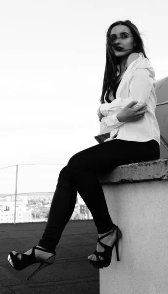 Mujer sexy joven posando en el techo, con chaqueta de leater, botín — Foto de Stock