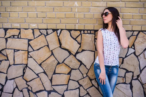 Glücklich stylisches Mädchen im trendigen Outfit mit Umhängetasche, spaziert auf der Stadtstraße und zeigt zahmes Lächeln in die Kamera. — Stockfoto