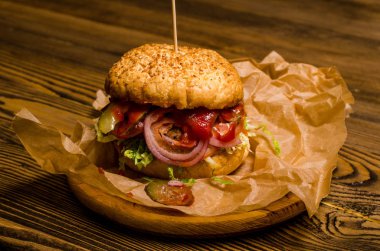 Pastırmalı hamburger ve ahşap masa.