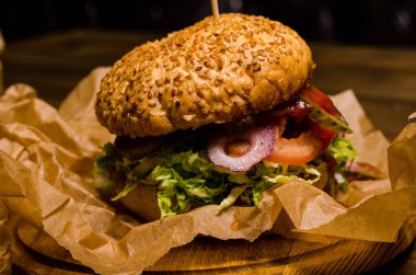 Pastırmalı hamburger ve ahşap masa.