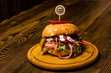 Pastırmalı hamburger ve ahşap masa.