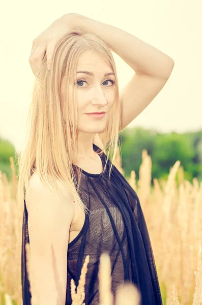 Ağaçlar ve gri tonlarında renkli uzun kuru otların arasında alanındaki gri ceket mavi gözlü güzel bir kız portresi 