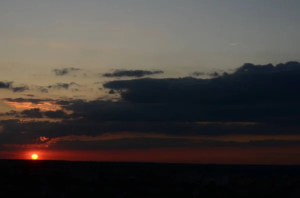 Naturlig solnedgång soluppgång över fält eller äng. Ljusa dramatiska himmel och mörk mark. Landskap på landet under vacker färgglad himmel vid solnedgången soluppgång. Sun Over Skyline, Horizon. Varma färger. — Stockfoto