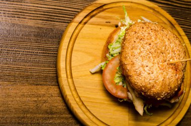 Pastırmalı hamburger ve ahşap masa.