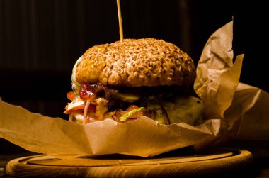 Pastırmalı hamburger ve ahşap masa.