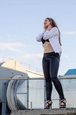 Çatıda poz veren genç seksi kadın, yaşam tarzı portresi.