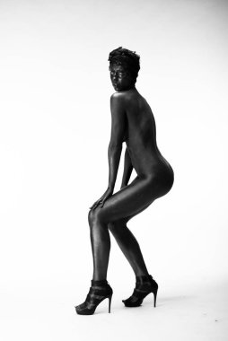 Çıplak kadın stüdyoda beyaz bir arka plan üzerinde siyah boyalı