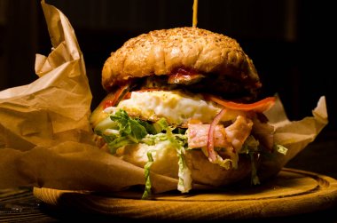 Pastırmalı hamburger ve ahşap masa.