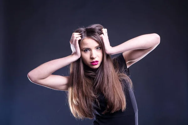 Retrato de uma bela jovem mulher em um vestido preto com uma maquiagem legal e boa pele. Estúdio, fundo preto . — Fotografia de Stock