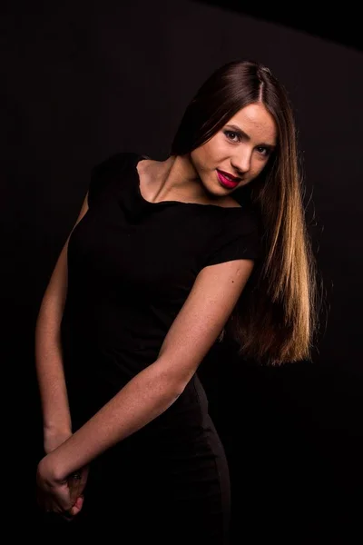 Porträt einer schönen jungen Frau in einem schwarzen Kleid mit coolem Make-up und guter Haut. Studio, schwarzer Hintergrund. — Stockfoto