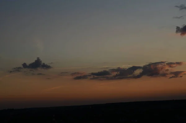 Naturlig solnedgång soluppgång över fält eller äng. Ljusa dramatiska himmel och mörk mark. Landskap på landet under vacker färgglad himmel vid solnedgången soluppgång. Sun Over Skyline, Horizon. Varma färger. — Stockfoto