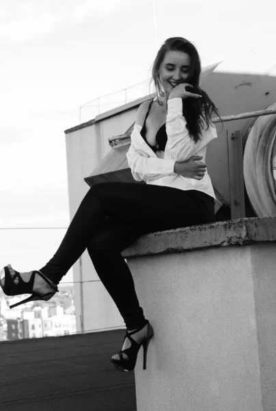 Молодая сексуальная женщина позирует на крыше, одета в кожаную куртку, шикарно — стоковое фото
