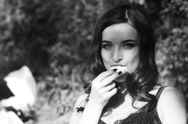 Lüks, komik, baştan çıkarıcı dudakları olan, manikürlü tırnakları olan, arka planda şekerleme yiyen, yakın plan portresi olan güzel bir kadının siyah ve beyaz fotoğrafçılığı..