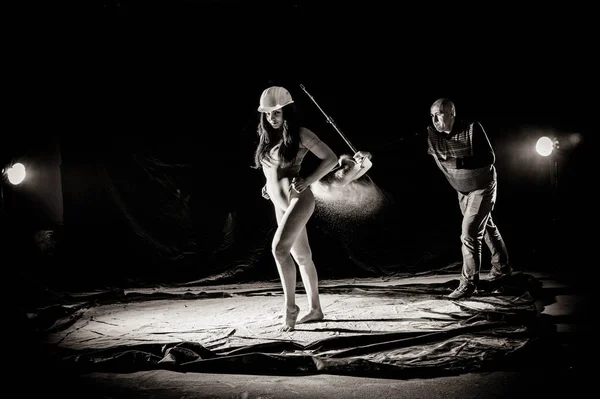 La fille avec la farine sur le corps étire les bras vers le haut avec de la farine jetée sur fond noir image noir et blanc — Photo