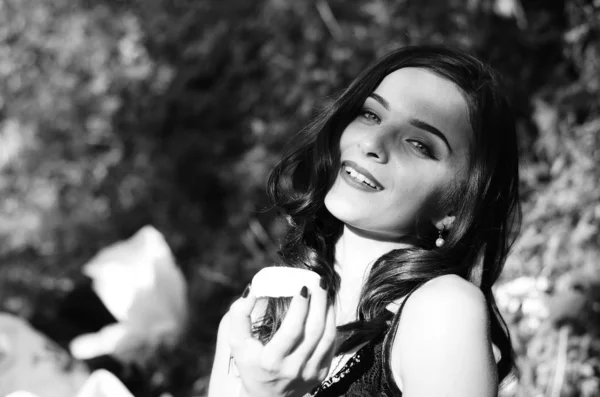 Zwart-wit fotografie van luxe grappige mooie jonge dame met verleidelijke lippen en gemanicuurde nagels eten snoep op lichte kopieerruimte achtergrond, close-up portret. — Stockfoto