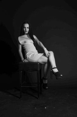 Mavi gece elbisesi poz uzun siyah kıvırcık saçlı genç güzel kadın. Muhteşem çarpıcı kız karanlık iç ayakta. Moda moda tarzı portre