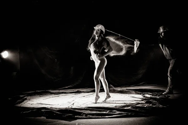 La fille avec la farine sur le corps étire les bras vers le haut avec de la farine jetée sur fond noir image noir et blanc — Photo