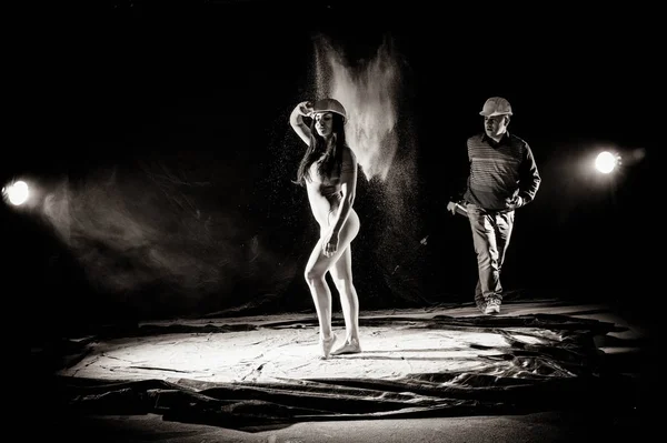 Dívka s moukou na těle roztáhne paže s hozena moukou na černém pozadí černobílém obrazu — Stock fotografie