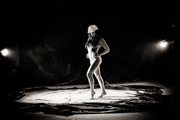 Flickan med mjölet på kroppen sträcker armarna upp med kastat mjöl på svart bakgrund svart och vit bild — Stockfoto