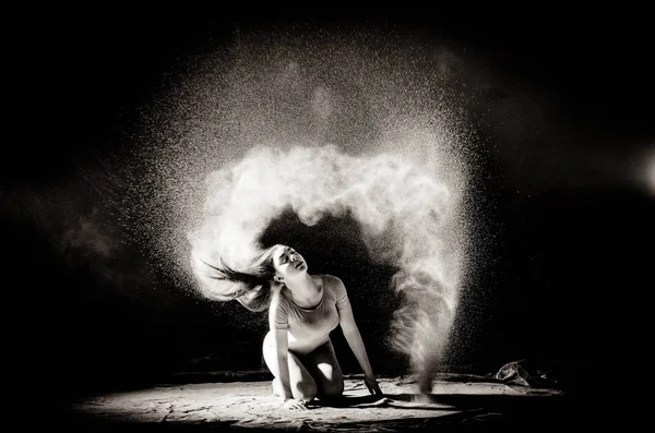 Dívka s moukou na těle roztáhne paže s hozena moukou na černém pozadí černobílém obrazu — Stock fotografie