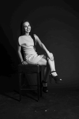 Mavi gece elbisesi poz uzun siyah kıvırcık saçlı genç güzel kadın. Muhteşem çarpıcı kız karanlık iç ayakta. Moda moda tarzı portre