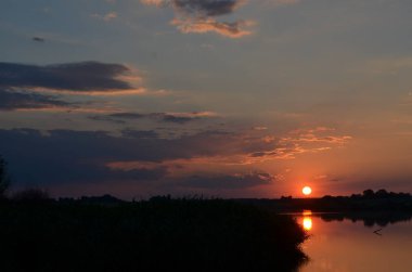 Gün batımında çimenler nehir manzarasında