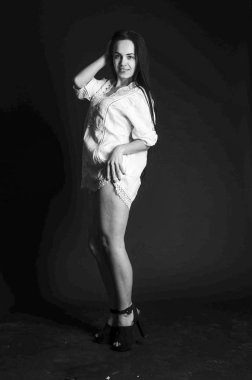 Mavi gece elbisesi poz uzun siyah kıvırcık saçlı genç güzel kadın. Muhteşem çarpıcı kız karanlık iç ayakta. Moda moda tarzı portre