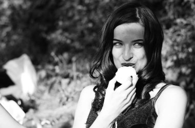 Lüks, komik, baştan çıkarıcı dudakları olan, manikürlü tırnakları olan, arka planda şekerleme yiyen, yakın plan portresi olan güzel bir kadının siyah ve beyaz fotoğrafçılığı..