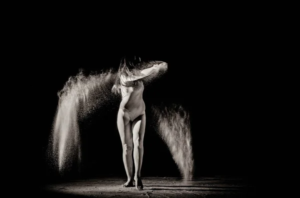 Дівчина з борошном на тілі розтягує руки кинутим борошном на чорно-білому тлі чорно-біле зображення — стокове фото