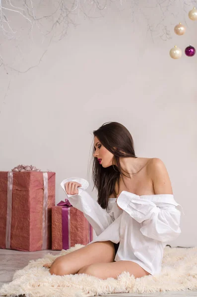 Fashion πορτρέτο του κοριτσιού μοντέλο σε εσωτερικούς χώρους με χριστουγεννιάτικο δέντρο. Χαριτωμένη γυναίκα με δαντέλα λευκά εσώρουχα. Γυναικείος κώλος με εσώρουχα. Γυμνό σώμα. — Φωτογραφία Αρχείου