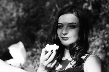 Lüks, komik, baştan çıkarıcı dudakları olan, manikürlü tırnakları olan, arka planda şekerleme yiyen, yakın plan portresi olan güzel bir kadının siyah ve beyaz fotoğrafçılığı..