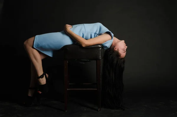 Mulher bonita nova com cabelo encaracolado preto longo posando em vestido de noite azul. Menina deslumbrante lindo em pé no interior escuro. Retrato de moda estilo moda . — Fotografia de Stock