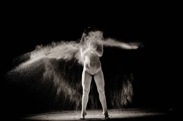 A lány a lisztet a test húzódik a karok fel dobott lisztet fekete háttér fekete-fehér kép — Stock Fotó