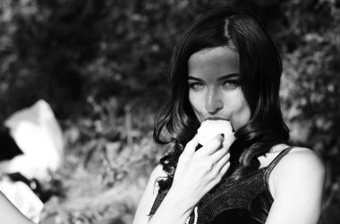 Lüks, komik, baştan çıkarıcı dudakları olan, manikürlü tırnakları olan, arka planda şekerleme yiyen, yakın plan portresi olan güzel bir kadının siyah ve beyaz fotoğrafçılığı..