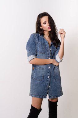 Çekici esmer güzellik sandalyede oturuyor.