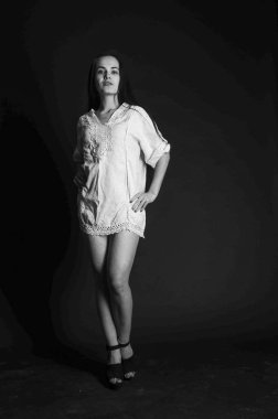 Mavi gece elbisesi poz uzun siyah kıvırcık saçlı genç güzel kadın. Muhteşem çarpıcı kız karanlık iç ayakta. Moda moda tarzı portre