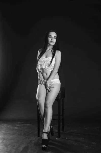 Sexy bruneta v prádelním pyžamu, pózová ve studiu, tmavé fotografie, dokonalý model, krásný make-up, rezavý studiový ateliér na zdech — Stock fotografie