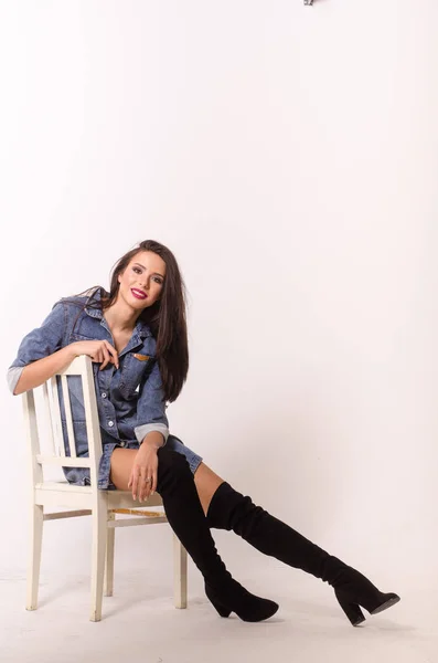 Stunning brunette beauty sitting on a chair — Stock Photo, Image