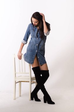 Çekici esmer güzellik sandalyede oturuyor.