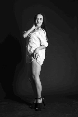 Mavi gece elbisesi poz uzun siyah kıvırcık saçlı genç güzel kadın. Muhteşem çarpıcı kız karanlık iç ayakta. Moda moda tarzı portre